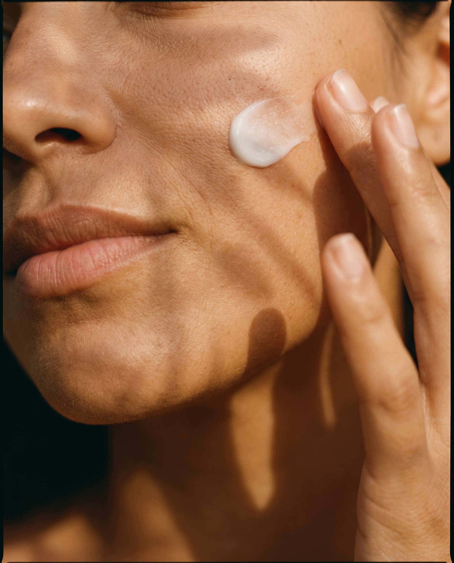 Aplicação de creme mineral branco na bochecha sob luz dourada da manhã